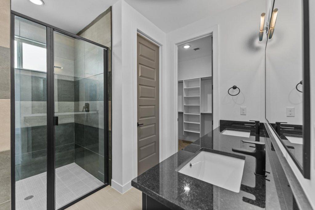 Primary bath with walk-in shower and dual vanity in a Hyperion M floorplan home by Nueva Luna Builders in El Paso, Texas